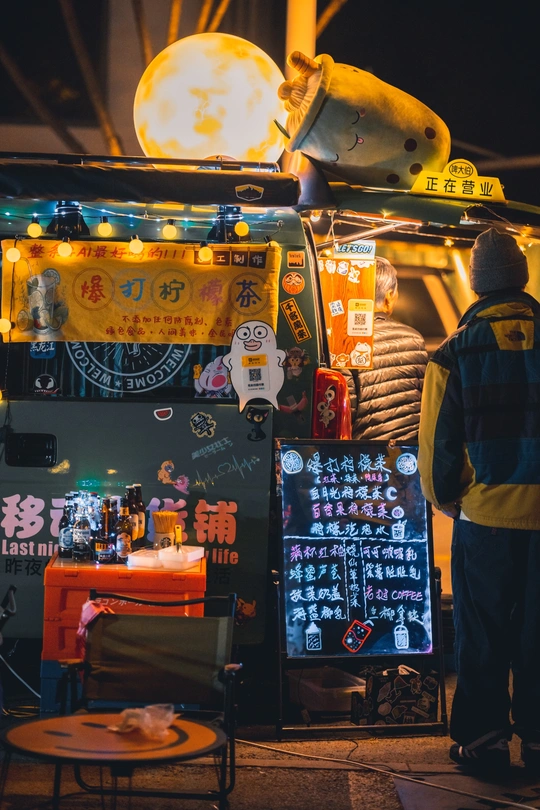 一个男人站在夜晚的食物卡车前