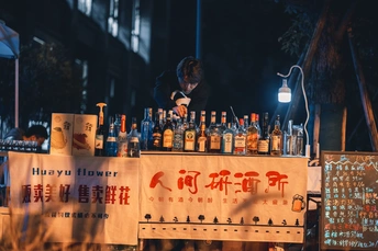 一个站在街边酒吧前卖饮料的男人