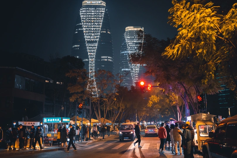 夜晚的城市街道 高楼林立 人们在街道上行走。