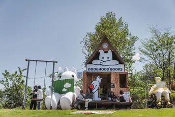 站在一个用假动物建成的小屋附近的田野上的人们