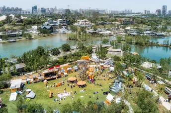 河边的广阔公园上空鸟瞰图 有帐篷和人