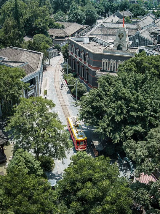 一辆黄色火车穿过一座拥有大型建筑的城市
