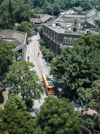 一辆黄色火车穿过一座拥有大型建筑的城市