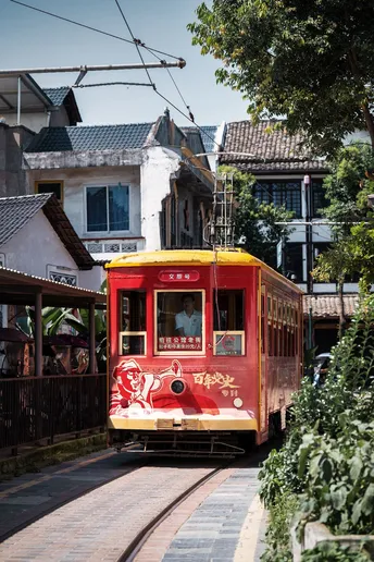 红色和黄色的小型有轨电车在城市街道上行驶