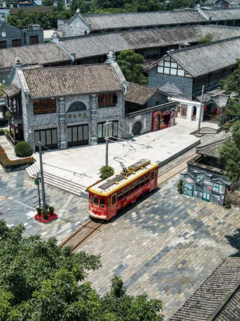 一个老镇 前面停着一辆红色的公共汽车或电车 旁边有一座大型建筑。