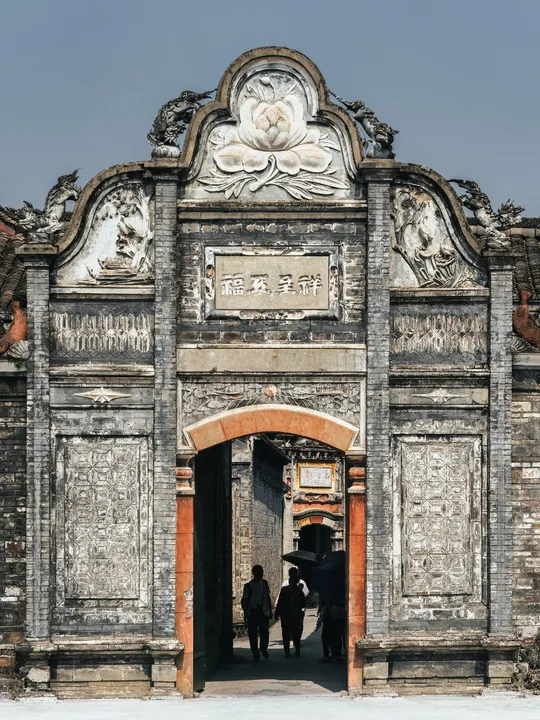 人们穿过一座老建筑的入口