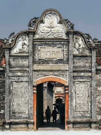人们穿过一座老建筑的入口