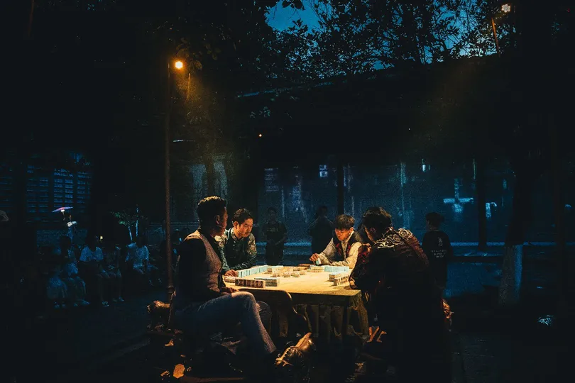 人们在夜晚的街头围坐在桌子旁