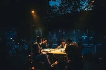 人们在夜晚的街头围坐在桌子旁