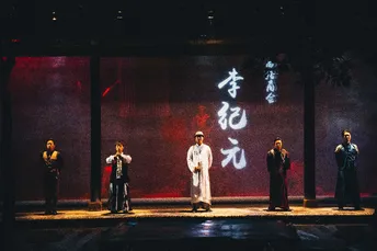 一个戏剧表演的场景 演员站在舞台上。