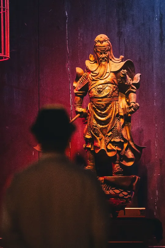 一个男人在寺庙里看着一座金雕像