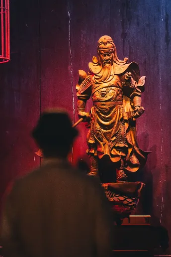 一个男人在寺庙里看着一座金雕像