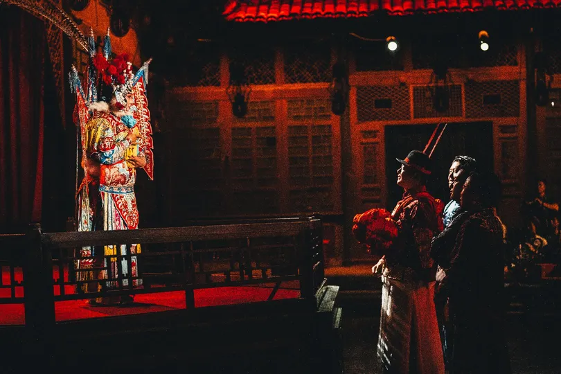 一个男人和一个女人站在夜晚的舞台上 前面有一栋建筑。