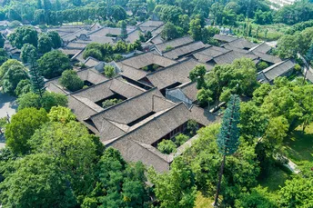 一个大庄园的空中视角 周围环绕着房屋和树木。