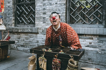 一个脸上涂着妆容的男子站在一个箱子前面