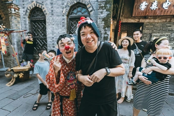 一个人穿着服装 带着婴儿和其他人站在他前面。