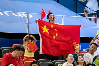 当人们为他们的队伍欢呼时 一名球迷挥舞着国旗。