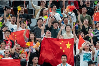 人们挥舞着国旗为他们的队伍欢呼