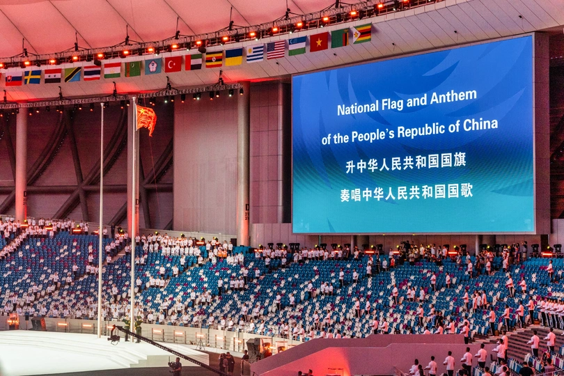 观众们在体育场观看一场体育赛事在大屏幕上播放。