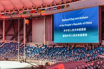 观众们在体育场观看一场体育赛事在大屏幕上播放。