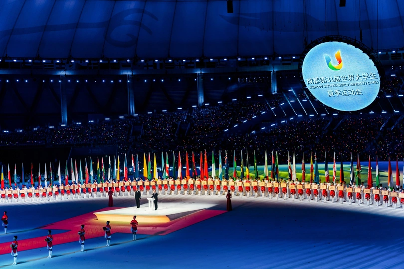 冬奥会开幕式上 一个大型溜冰场被五颜六色的旗帜和冰上的人们照亮。