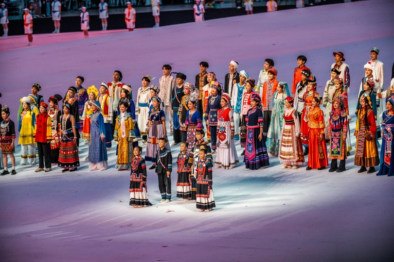 表演者们身着多彩传统服装站在舞台上参加节日活动。