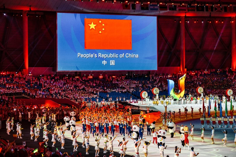 中心舞台的大型屏幕上播放着奥运会队伍的表演 观众们在体育场里聚集了大量人。