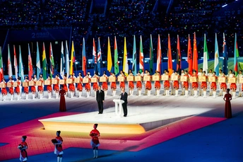 表演者在一场文化活动中站在不同颜色旗帜的彩色舞台上。