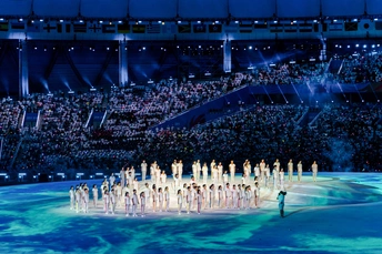 表演者站在体育场前面的舞台上 面对着人群。