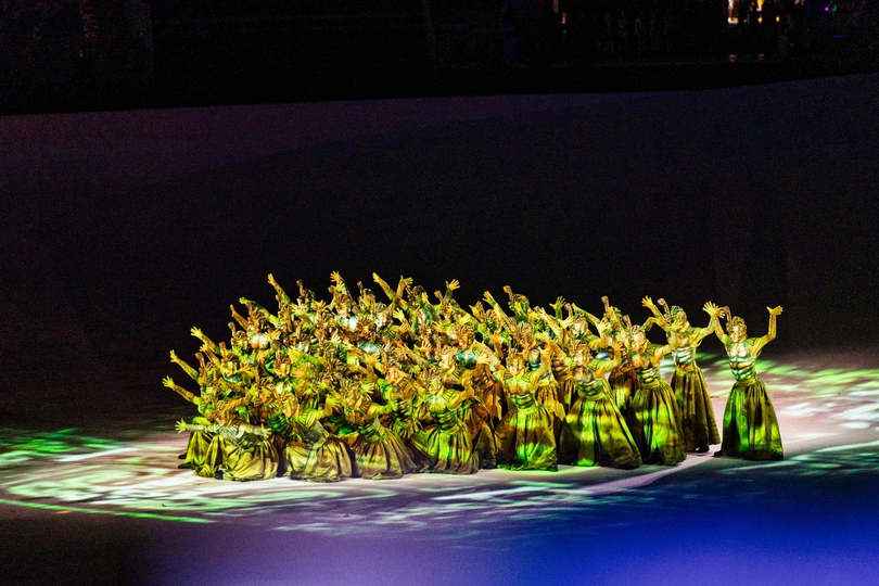 一些舞者在舞台上表演 穿着绿色冰鞋。