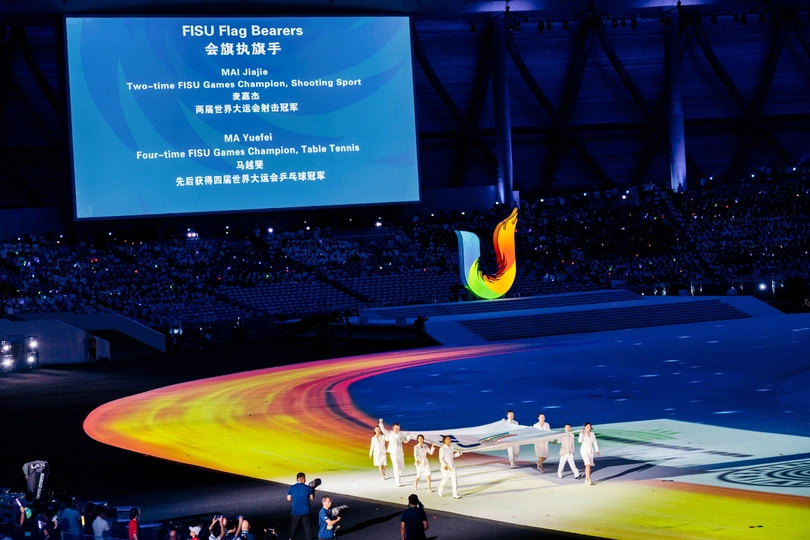 一个有大型屏幕的舞台 一群舞者在舞台上为一大群人表演。