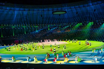 表演者与舞者在一场表演期间在大型体育场跳舞。