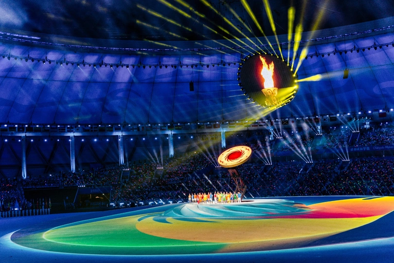 空中飞舞的奥林匹克五环在有灯光的体育场中