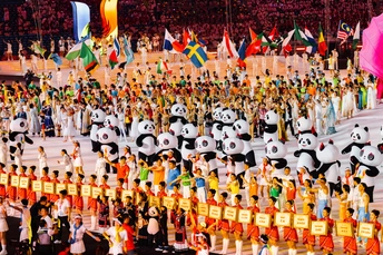 很多人站在一群熊猫的前面