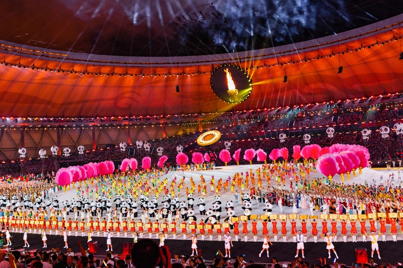 表演者在粉红色烟花背景下的体育场表演