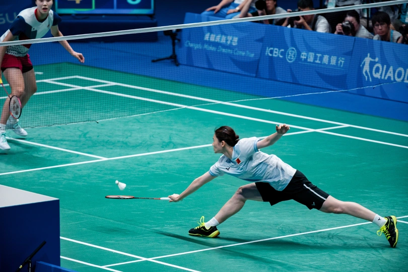 一些人正在网球场打羽毛球。