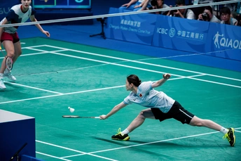 一些人正在网球场打羽毛球。