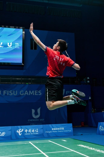 一个年轻人拿着网球拍在场上发球