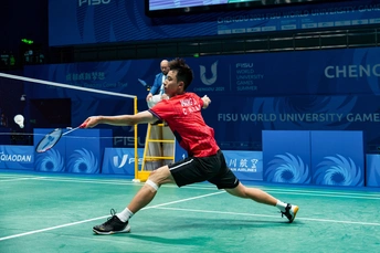 一个正在打羽毛球的男子 持拍