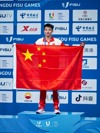 一位举着红旗的男子站在领奖台上 手里拿着一枚金牌。