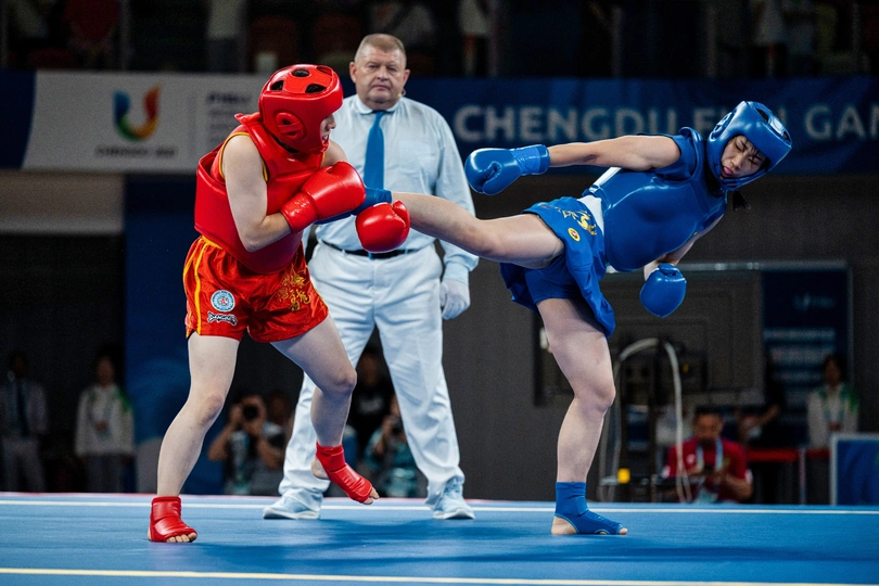 一个摔跤手与裁判员在背景中进行一场比赛