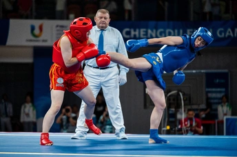 一个摔跤手与裁判员在背景中进行一场比赛