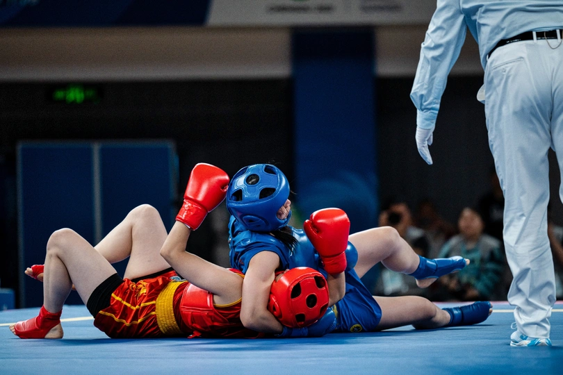 摔跤手与一个小孩在地板上较量 一名裁判在观察 照片由<人>/getty images拍摄