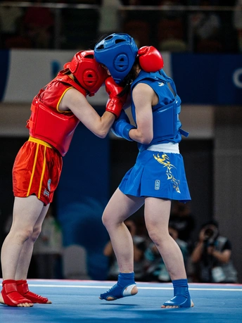 一个摔跤手和一个背景中的人进行一场比赛