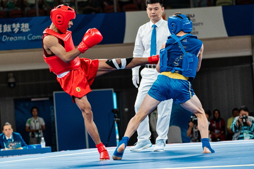 一个男子在泰拳比赛中与另一个男子在背景中