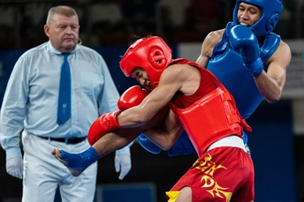 一名拳击手在拳击比赛中从裁判那里踢出一记拳