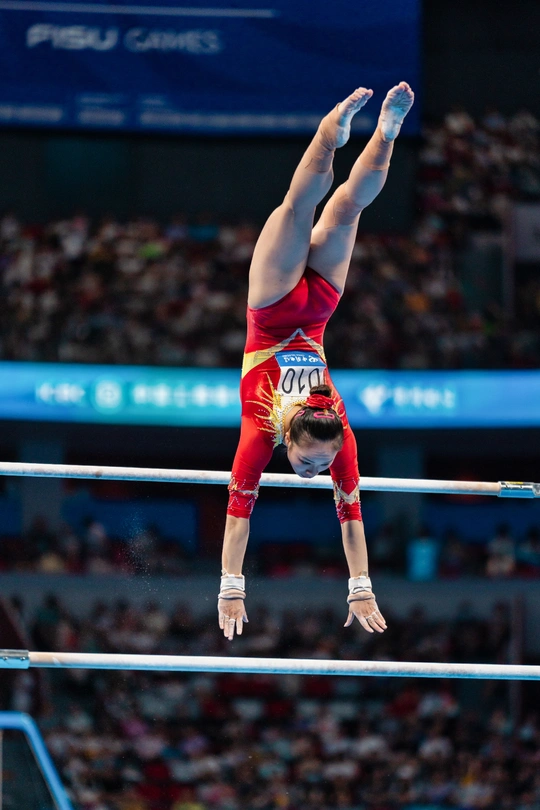 女子个人全能决赛中 运动员在高低不平的平衡木上表演。