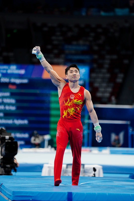 一名男性运动员在比赛中进行 beam 表演