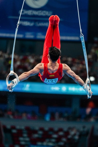 运动员在男子个人全能决赛中在 rings 上表演