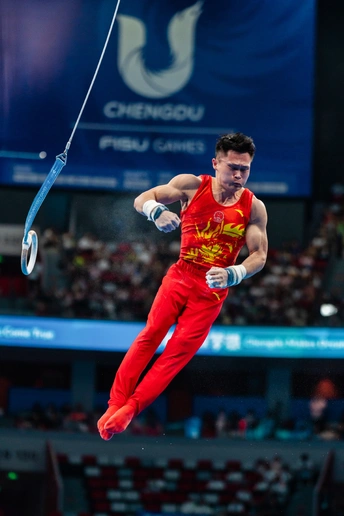 一位男性运动员在比赛中表演吊环